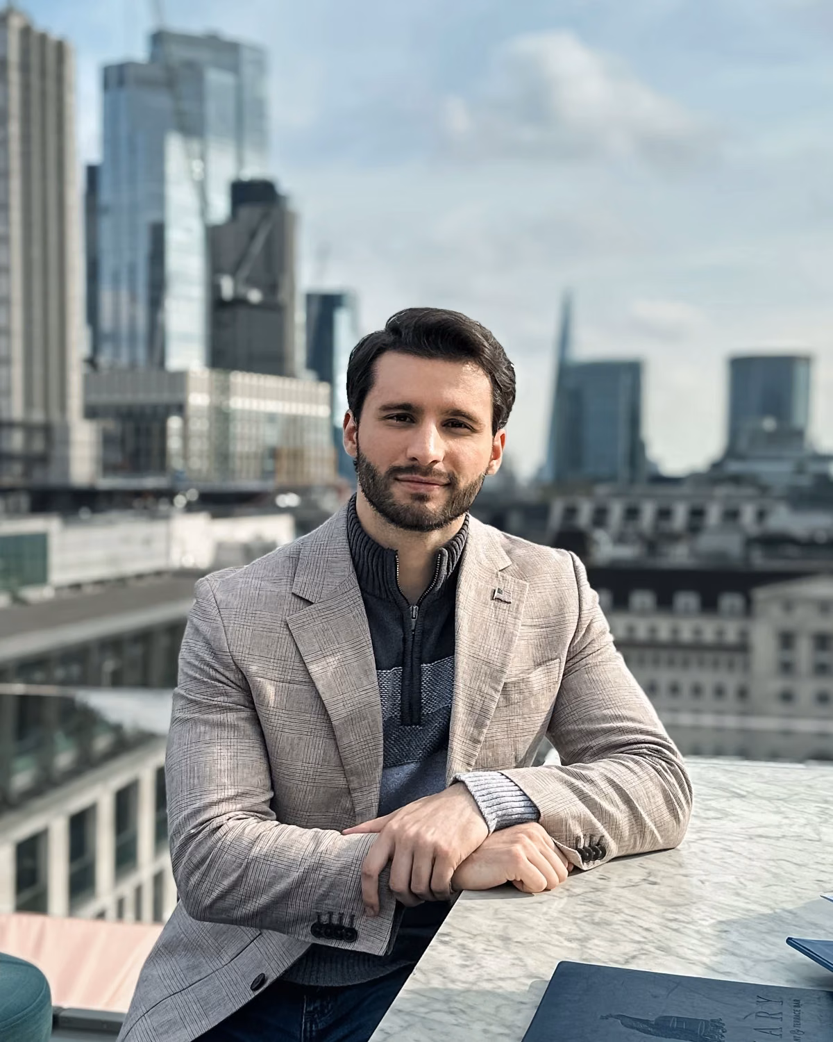 Matthew A. Schneider on a rooftop overlooking the city skyline